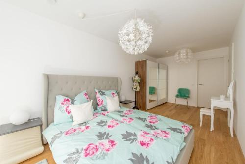 1 dormitorio con 1 cama grande con flores rosas en Sweet Home Vienna Garden en Viena