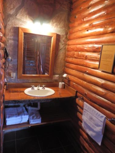 baño con lavabo en una cabaña de madera en Las Cortaderas Cabañas de Tronco en Nono