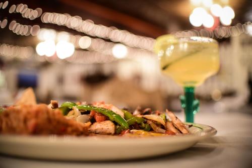 a plate of food on a table with a glass of wine at Hotel El Rancho in Gallup