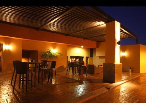 eine Terrasse mit einem Tisch und Stühlen in einem Gebäude in der Unterkunft Hotel Gandara in Hermosillo