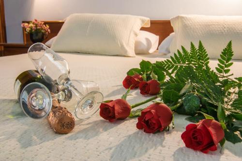 a bouquet of red roses on a bed at Pousada Brisa do Mar in Torres