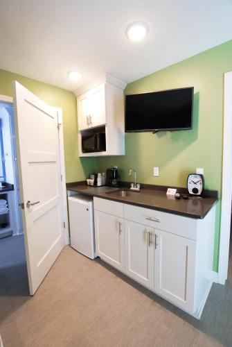 a kitchen with a sink and a tv on the wall at Homestead Suites - Fish Creek in Fish Creek