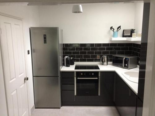 a kitchen with a stainless steel refrigerator and a sink at 3 Summertown Court in Oxford