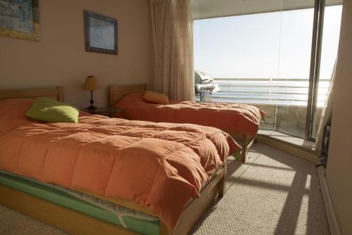 2 camas en una habitación con ventana en San Alfonso del Mar - Algarrobo 886, en Algarrobo