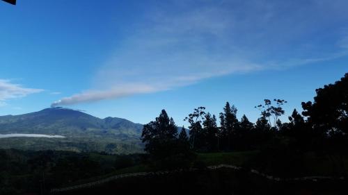 a view of a mountain with a rainbow in the sky at Finca Tres Equis - Farm and Forest in Tres Equis