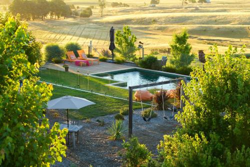 a garden with a swimming pool and an umbrella at 187 Merrijig in Merrijig