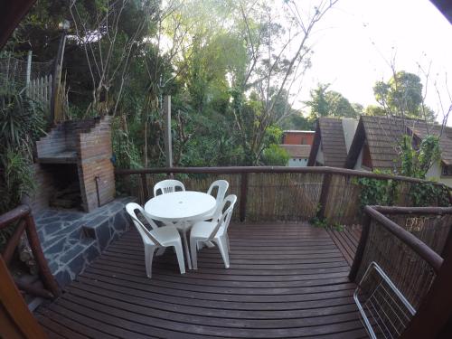 a wooden deck with a table and chairs on it at Cabañas Manamar in Villa Gesell