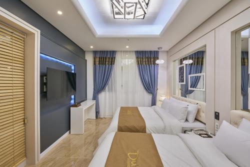 a bedroom with two beds and a flat screen tv at Dubai Hotel in Gwangju