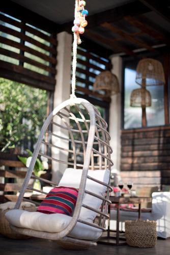 a hanging chair with pillows on a porch at Punta Ballena Lodge in Pichilemu