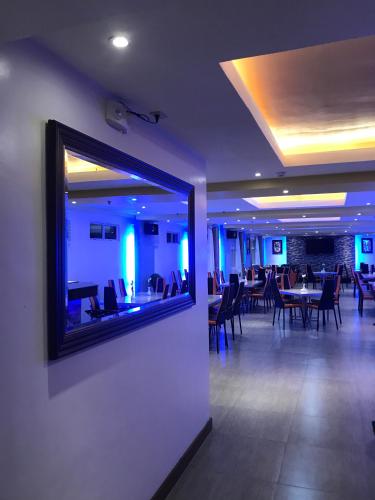a dining room with tables and chairs and a large mirror at Royal Mansion Hotel in Tabaco