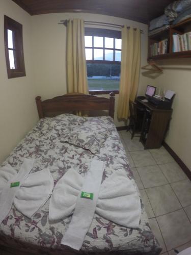 a bedroom with a bed with towels on it at Casa em Paraty a 7 min. do Centro histórico in Paraty