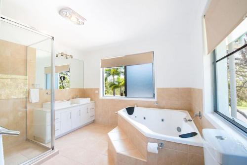 y baño con bañera, ducha y lavamanos. en Torquay Terrace Bed & Breakfast en Hervey Bay