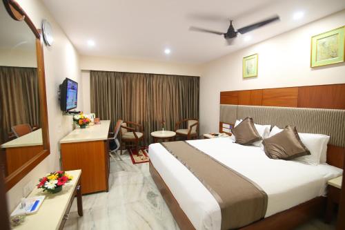 a hotel room with a large bed and a desk at Daspalla Executive Court in Visakhapatnam