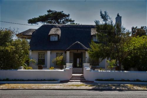 a white house with a black roof at Howards End Manor B&B in Cape Town
