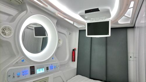 a hospital room with a mirror and a tv at Stay With Me Capsules Hostel in Malacca