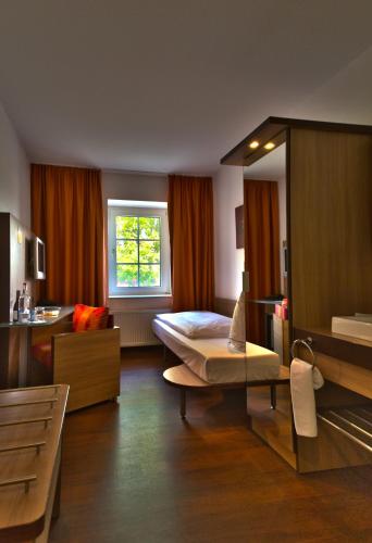 a hotel room with a bed and a window at Brackstedter Mühle e.K. in Wolfsburg