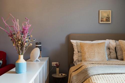 um quarto com uma cama com um vaso de flores sobre uma mesa em Engel Apartman em Budapeste