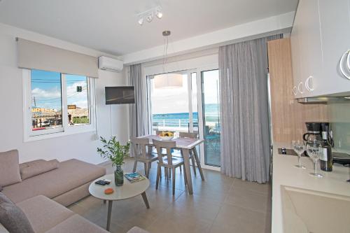 a living room with a couch and a table at Sonja Beachfront Apartments in Kato Daratso