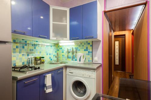 cocina con armarios azules y lavadora en LuxApartments-Даев переулок, en Moscú