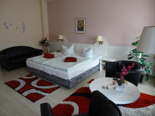 a bedroom with a bed and a table and chairs at Hotel Elisenhof in Chemnitz