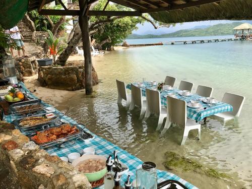 a table on the beach with food in the water at La Estancia Busuanga in Busuanga