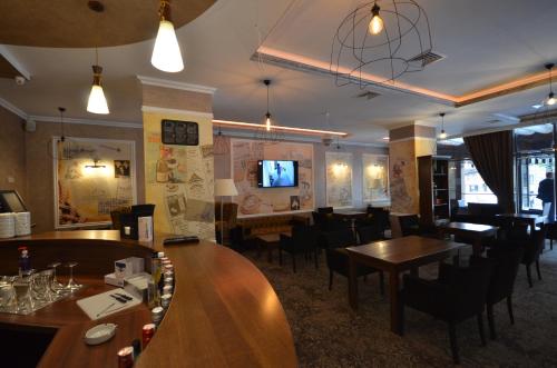 a restaurant with wooden tables and chairs and a bar at Hotel Yaky Center in Piteşti