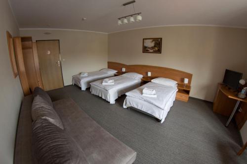 Un pat sau paturi într-o cameră la Hotel Sukiennice