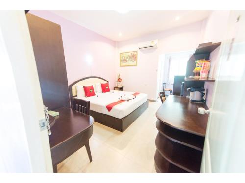 a bedroom with a bed and a desk in a room at Feelathome in Chiang Rai