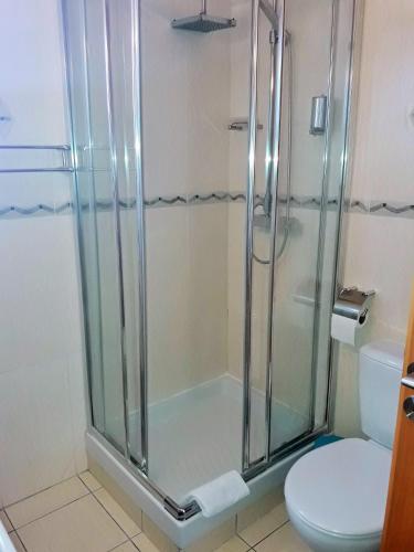a bathroom with a glass shower with a toilet at 16 SANDY BEACH in Larnaca