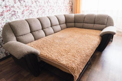 a couch with a blanket on it in a room at Apartment on Mira 3/1 in Orenburg