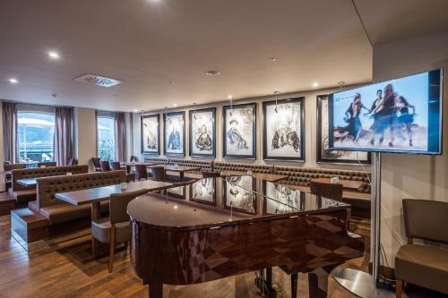 a restaurant with tables and chairs and a flat screen tv at Vila Gale Porto Ribeira in Porto