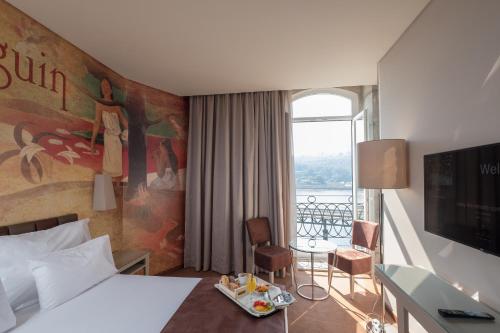 ポルトにあるヴィラ ガレ ポルト リベイラのベッドとバルコニー付きのホテルルーム