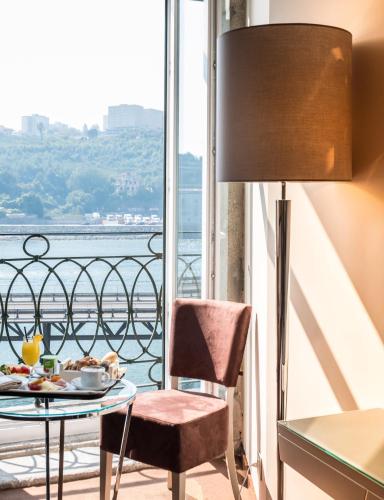 a table with a plate of food and a lamp at Vila Gale Porto Ribeira in Porto