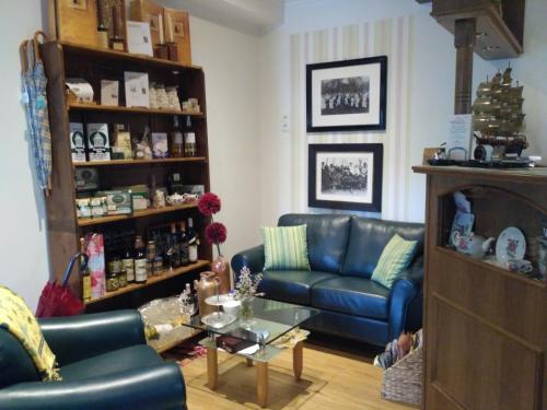 a living room with a blue couch and a table at Stoevchen Café Hotel in Papenburg