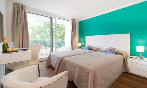 una camera con un grande letto e una grande finestra di Apartamentos Miramar a Port de Pollença