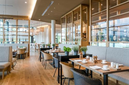 a restaurant with wooden tables and chairs at Seezeitlodge Hotel & Spa in Gonnesweiler