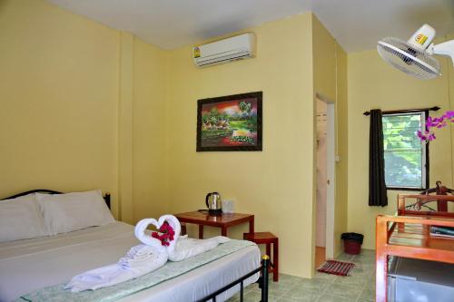 a bedroom with a bed with towels on it at TP Hut Bungalows in Ko Chang