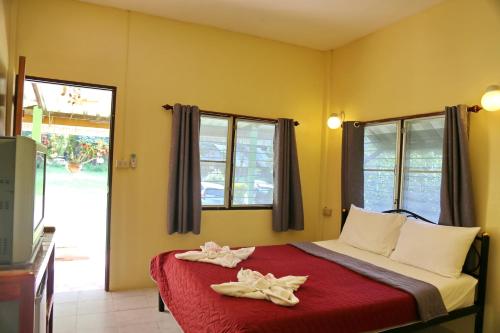a bedroom with a bed with two towels on it at TP Hut Bungalows in Ko Chang