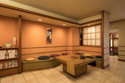 una sala de espera con una mesa y un banco en Hotel Shirakawa Yunokura en Nikko