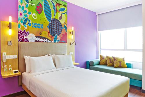 a bedroom with a large bed and a couch at Ibis Styles Kuala Lumpur Fraser Business Park in Kuala Lumpur