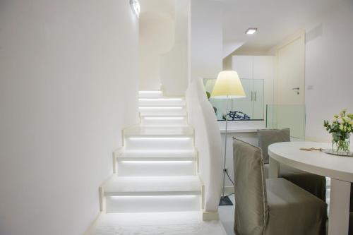 escalera blanca en una habitación con mesa en White Stylish Apartments, en Vico Equense