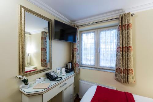 Zimmer mit einem Bett und einem Spiegel in der Unterkunft Linton Hotel Luton in Luton