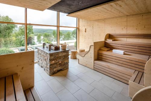 a sauna with wooden walls and a large window at Seezeitlodge Hotel & Spa in Gonnesweiler
