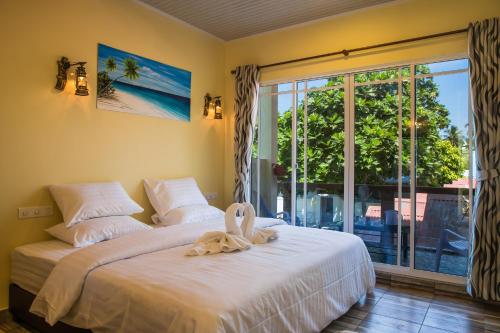 圖杜的住宿－馬爾代夫托多輕鬆旅館，一间卧室配有一张床,床上有毛巾