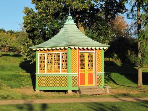 a colorful gazebo with a green roof in the grass at Liselund Ny Slot Hotel in Borre