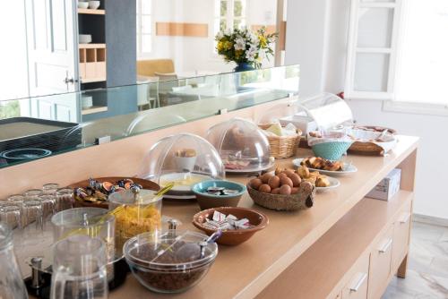 a kitchen counter with many bowls of food on it at Far Out Hotel & Spa in Mylopotas