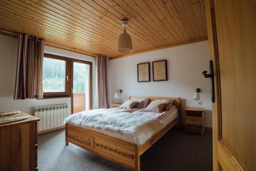 a bedroom with a bed with a wooden ceiling at Haus Izabella in Filzmoos