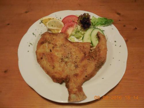 a plate of chicken with vegetables on a table at Haus Nixe in Loddin