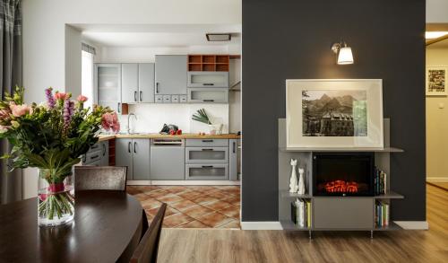 a kitchen and dining room with a table and a fireplace at Apartament nad Cukiernią in Zakopane