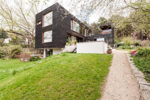 a black house on a hill with a garden at Ferienwohnung am Einsteinhaus Caputh in Caputh